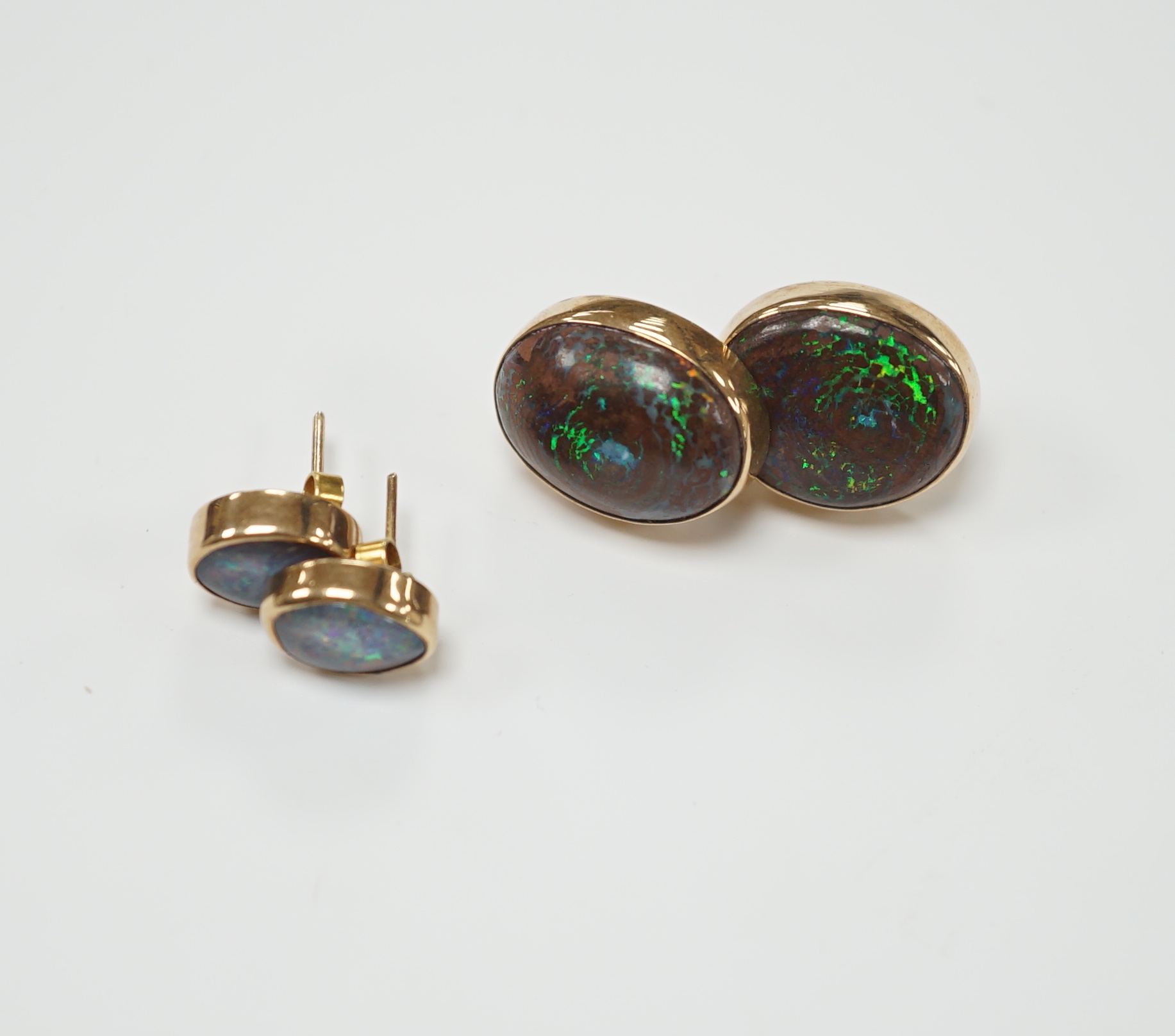 Two pairs of yellow metal and oval opal doublet set earrings, the smaller stamped 9ct, largest 17mm, gross weight 11 grams.